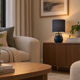 Navy blue table lamp with fabric drum shade and brushed metal detail